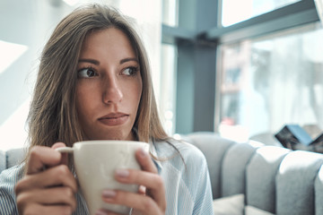 A girl is drinking coffee. Pastel shades. Wooden light table