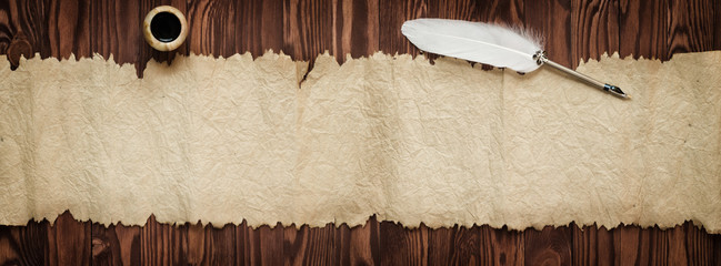 Goose feather and old paper, vintage background for text, panorama.