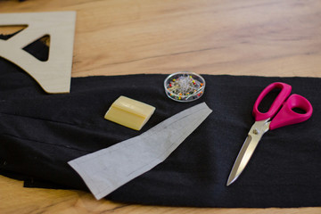 Sewing accessories, tools and cloth on seamstress table  