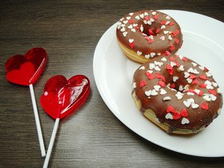 Fototapeta na wymiar heart lollipops donuts sweet love valentine's day on wooden background