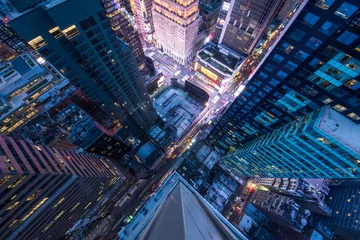 Bird's eye view of Manhattan, looking down at people and yellow taxi cabs going down 5th Avenue.