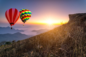 Hot air balloon with tourist is traveling into the peak of mountain and cloudscape at Phu chi fa in Chiangrai Provice, Thailand