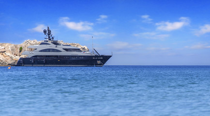 Fototapeta na wymiar Big luxury beautiful yacht docked at summer sea but ready to travel to tropical beautiful water