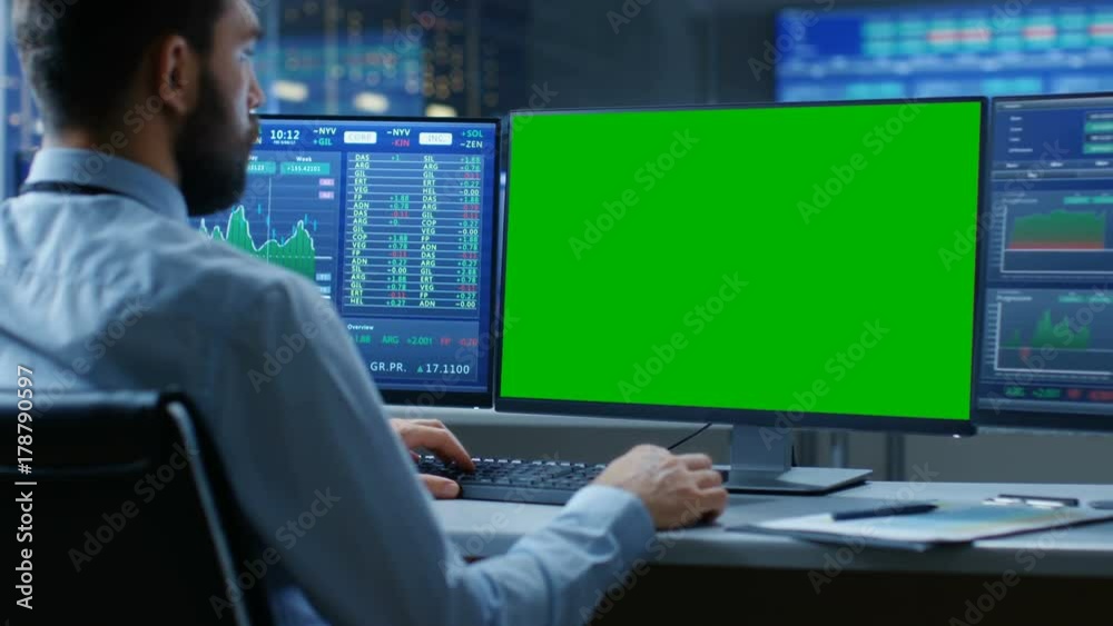 Aufkleber Over the Shoulder View of Stock Market Trader Working on a Computer with Isolated Mock-up Green Screen and Second Display Showing Number Ticker with Graphs. 