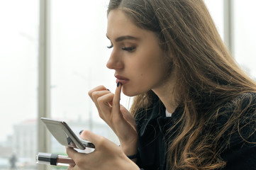 Portrait of a girl who paints her lips