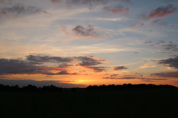 Bewölkter, oranger Sonnenuntergang