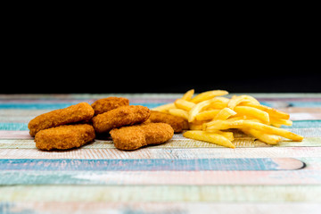 Chicken nuggets with sauce and golden French fries potatoes