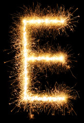 Sparkler firework light alphabet E isolated on black