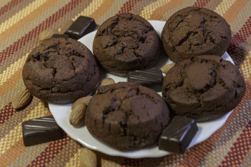 Fototapeta premium Chocolate Cookies on White Saucer. White Saucer on Color Napkin.