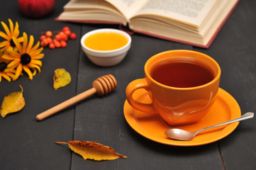 Autumn still life cup of tea, honey and book on the table
