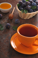 A cup of tea and plum on the table