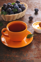 A cup of tea and plum on the table