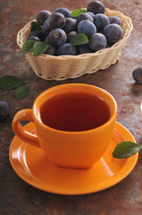 Obraz na płótnie Canvas A cup of tea and plum on the table