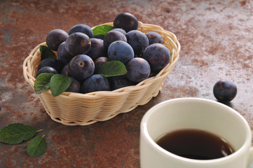 A cup of tea and plum on the table