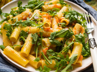 Pasta with pumpkin, onion and arugula. Closeup