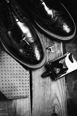 Fototapeta na wymiar male black shoes and perfume in wooden background