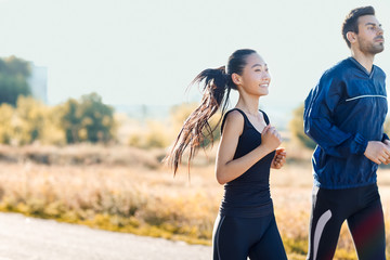 Two friends man and woman jogging on sunny day