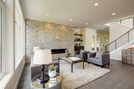 Modern great room with a floor to ceiling stone fireplace