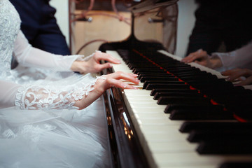 Hands of the bride playing the piano on a holiday on the wedding day