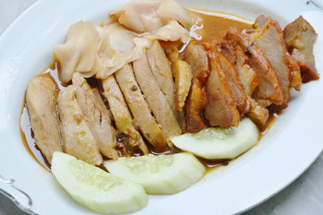 roasted duck and sweet barbecue pork in sauce on plate