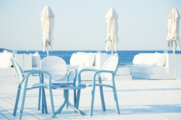 Chairs and table of beach near sea.