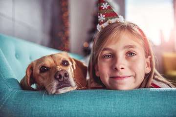 Little girl with yellow dog posing on sofa