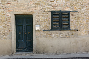 Puerta de madera verde y persiana veneciana.