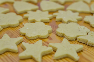 Gingerbread Christmas cookies, on a kitchen table, glazed with chocolate and sprinkled with powdered sugar, diffrent shapes. Concept Christmas.