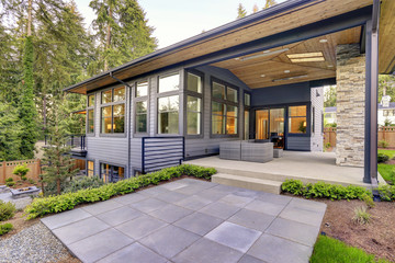 Fototapeta na wymiar New modern home features a backyard with patio