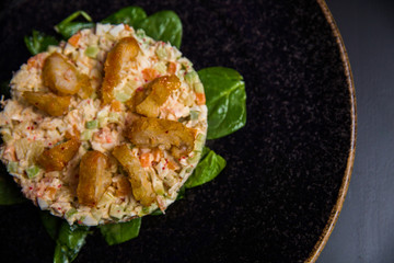salad dressed with mayonnaise, crab sticks, cucumber, pepper, and egg on plate