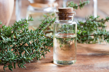 A bottle of thyme essential oil with fresh thyme twigs