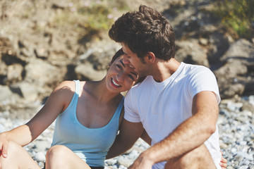 Happy couple sitting outside hugging each other