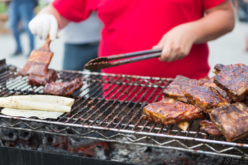 Pork ribs cooking on grill at bbq party