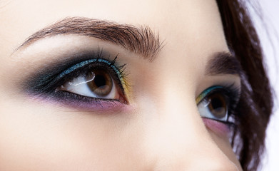 Naklejka premium Closeup macro shot of human female eye. Girl with perfect skin and lilac - blue - yellow eyes shadows