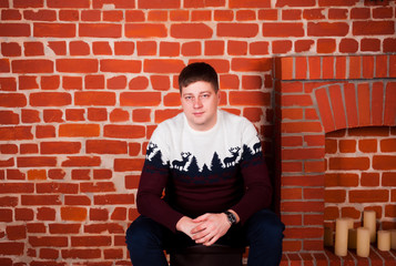 Fototapeta na wymiar a young man in a New Year's sweater with a deer and New Year's mood