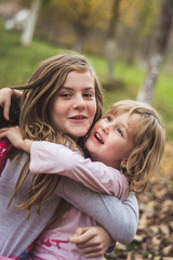 Fototapeta premium Young sisters hugging and smiling happy in the garden.