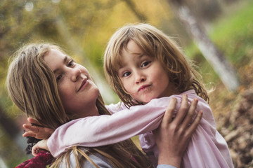 Young sisters playing together in the garden.