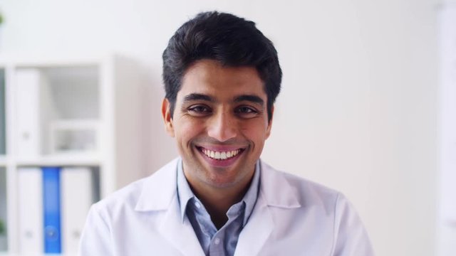 portrait of happy smiling young indian male doctor
