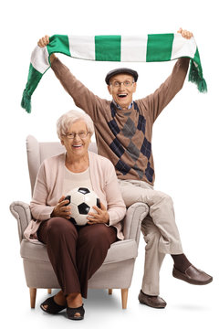 Overjoyed elderly soccer fans sitting in an armchair