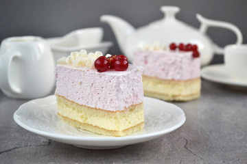 ruit  Mousse Cake, decorated fresh red berries and grated white chocolate, in a white plate.  Minimal baking and a light, chilled dessert with fresh fruit flavors. 