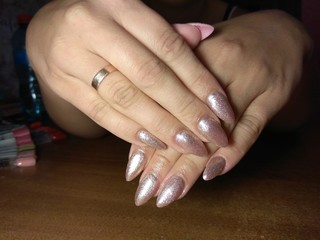 The manicurist excellently made her work a beautiful manicure with a polish gel on her hands and the client is happy