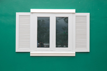 Picturesque window on green wall of house. Italy home style