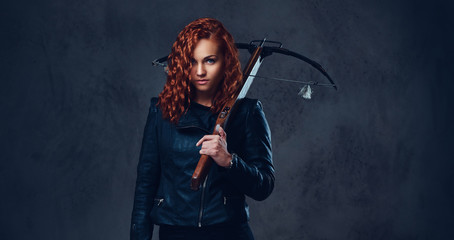 Redhead female  holds crossbow.