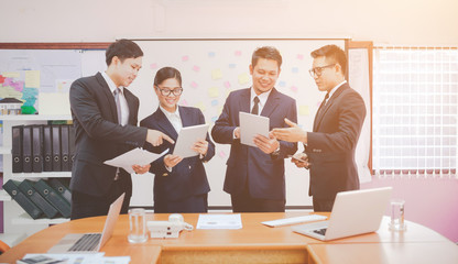 Image of two young businessmen using touchpad at meeting