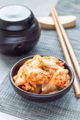 Kimchi cabbage. Korean appetizer in ceramic bowl, vertical