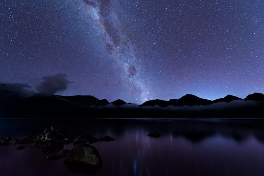 Milky Way landscape. Clearly Milky way above Lake Segara Anak inside crater of Rinjani mountain on night sky. Lombok island, Indonesia.