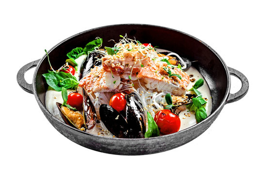 Gourmet Asian meal mad of seafood such as sea bass fish, mussels, crab meat and cockles with vegetables and rice noodles isolated on white.