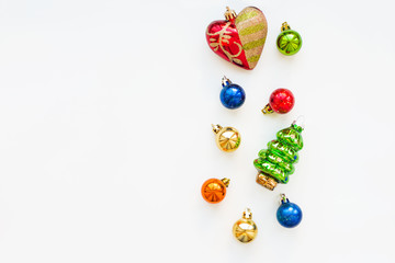 Obraz premium Christmas background with decorations. New Year symbol - fir tree. Shiny colorful balls and red heart. Flat lay, top view. Place for text.