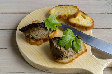 liver pate with toast on a round Board