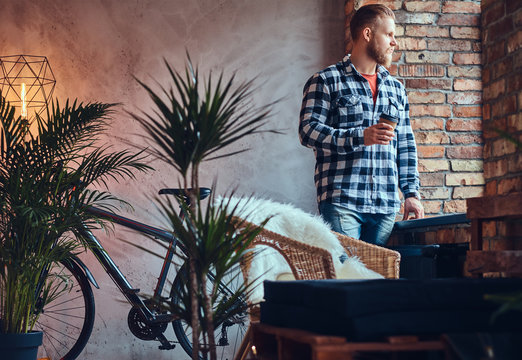 The full body image of blond hipster male drinks coffee.